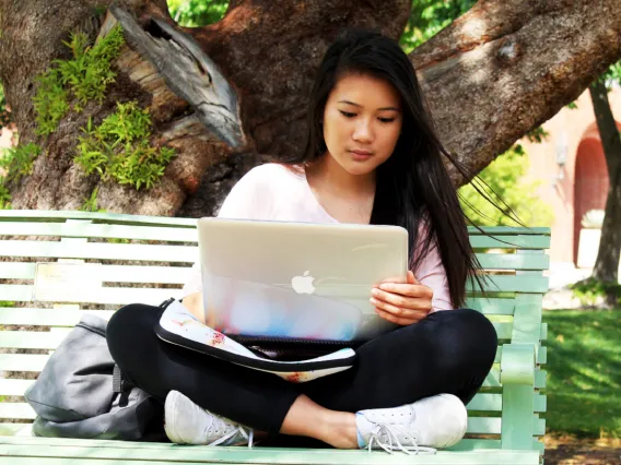 Girl with laptop on bench